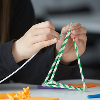 Student working on a construction activity with straws.